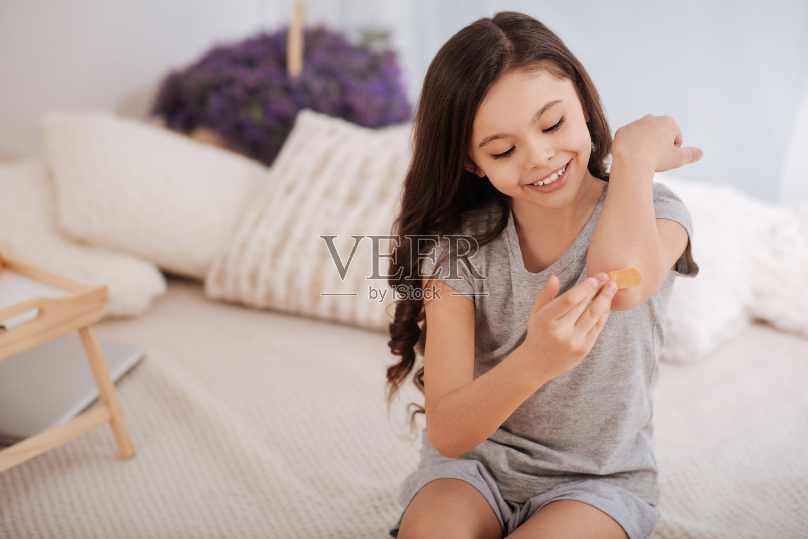 快乐的孩子在家治疗肘部的伤口照片摄影图片