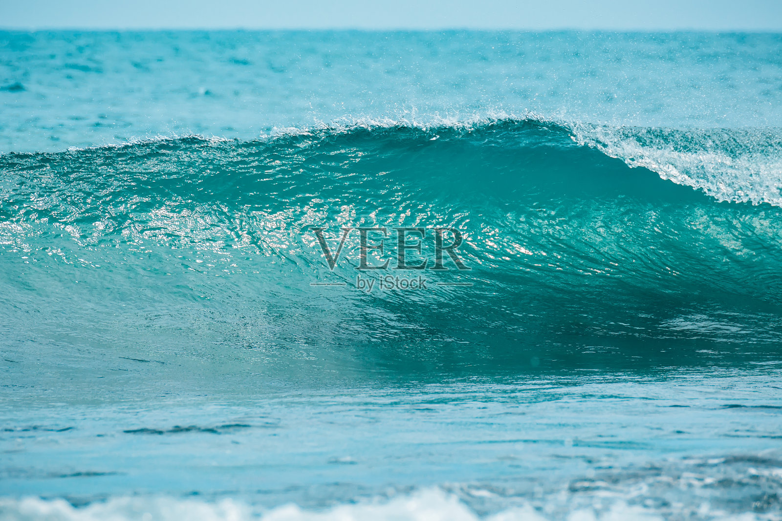 热带海洋中理想的蓝色波浪。浪桶的撞击和清澈的水。照片摄影图片