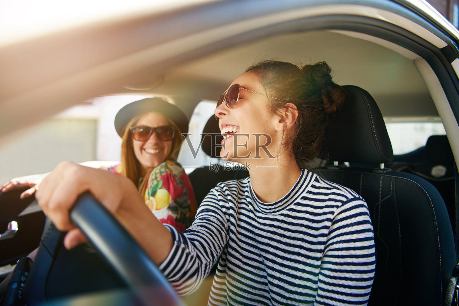 微笑的快乐女人让她的朋友搭便车照片摄影图片