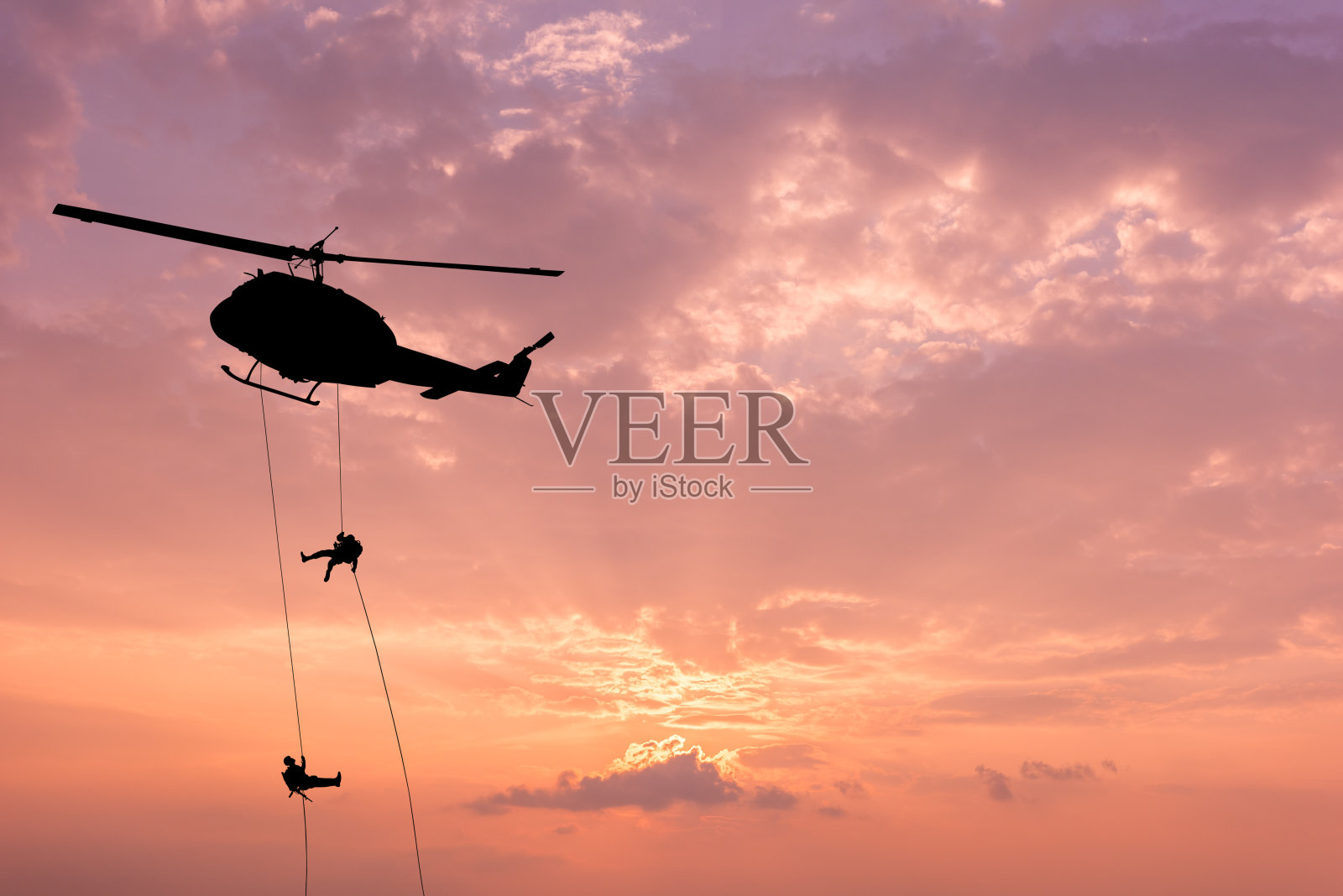 直升机的剪影，士兵救援行动直升机在日落天空的背景。照片摄影图片