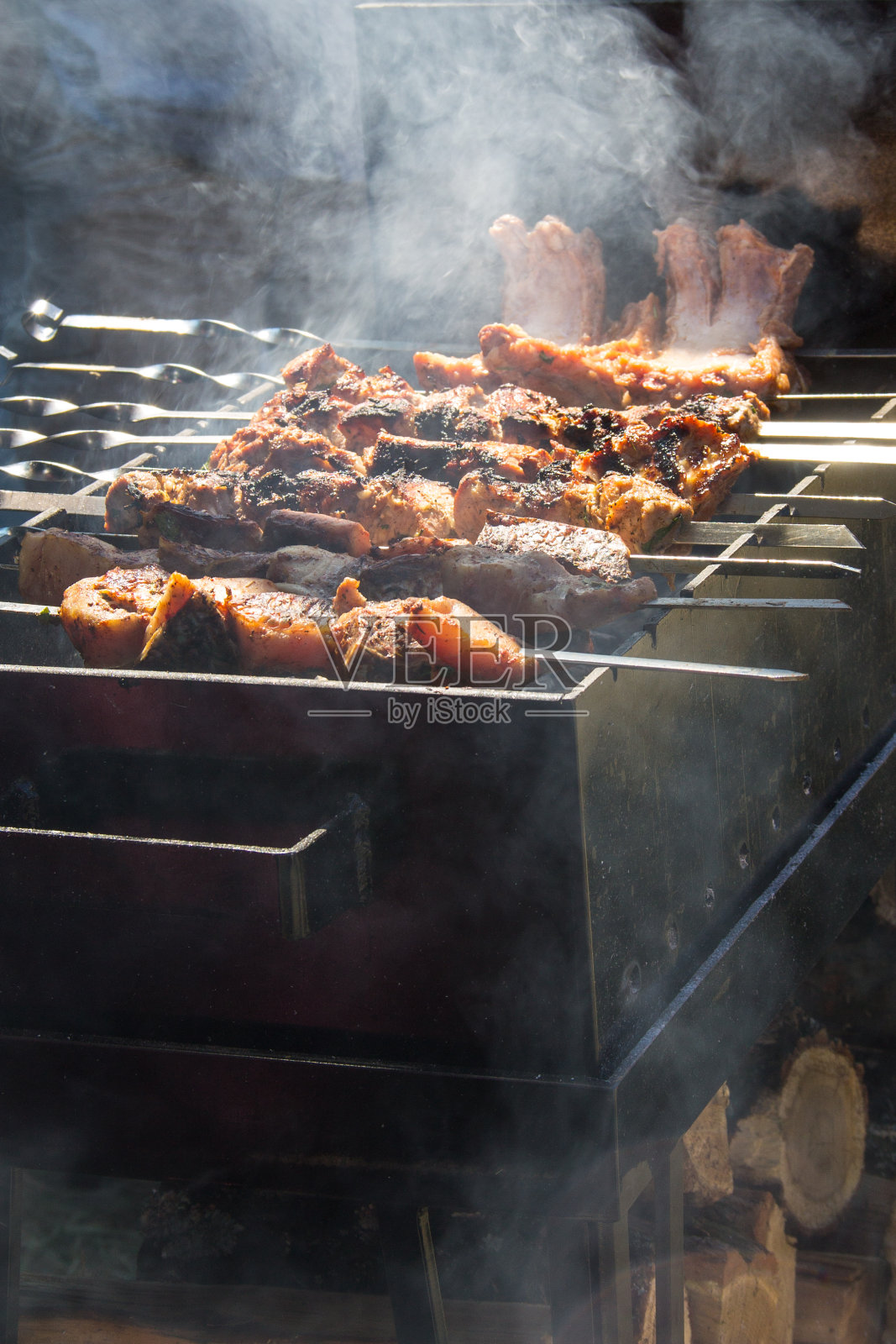 用金属串烤的烤肉串。烤肉烧烤时烤的肉传统的东方菜肴，羊肉串。炭火烧烤，野餐，街头小吃照片摄影图片