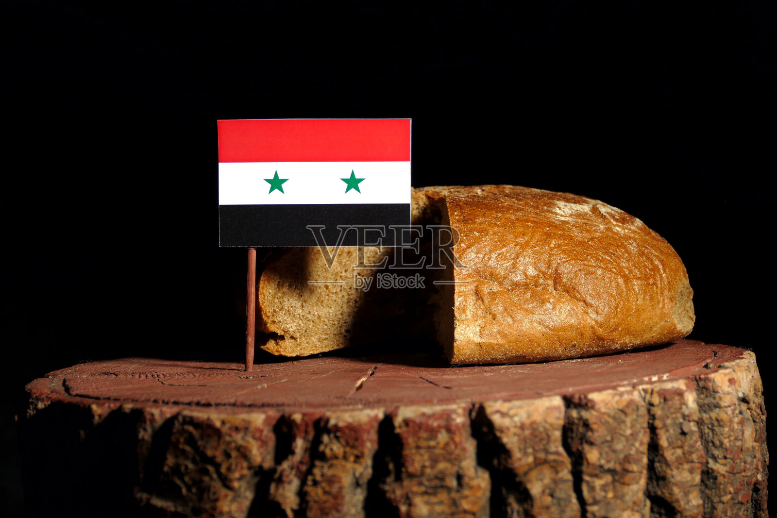 树桩上挂着叙利亚国旗，面包被孤立照片摄影图片