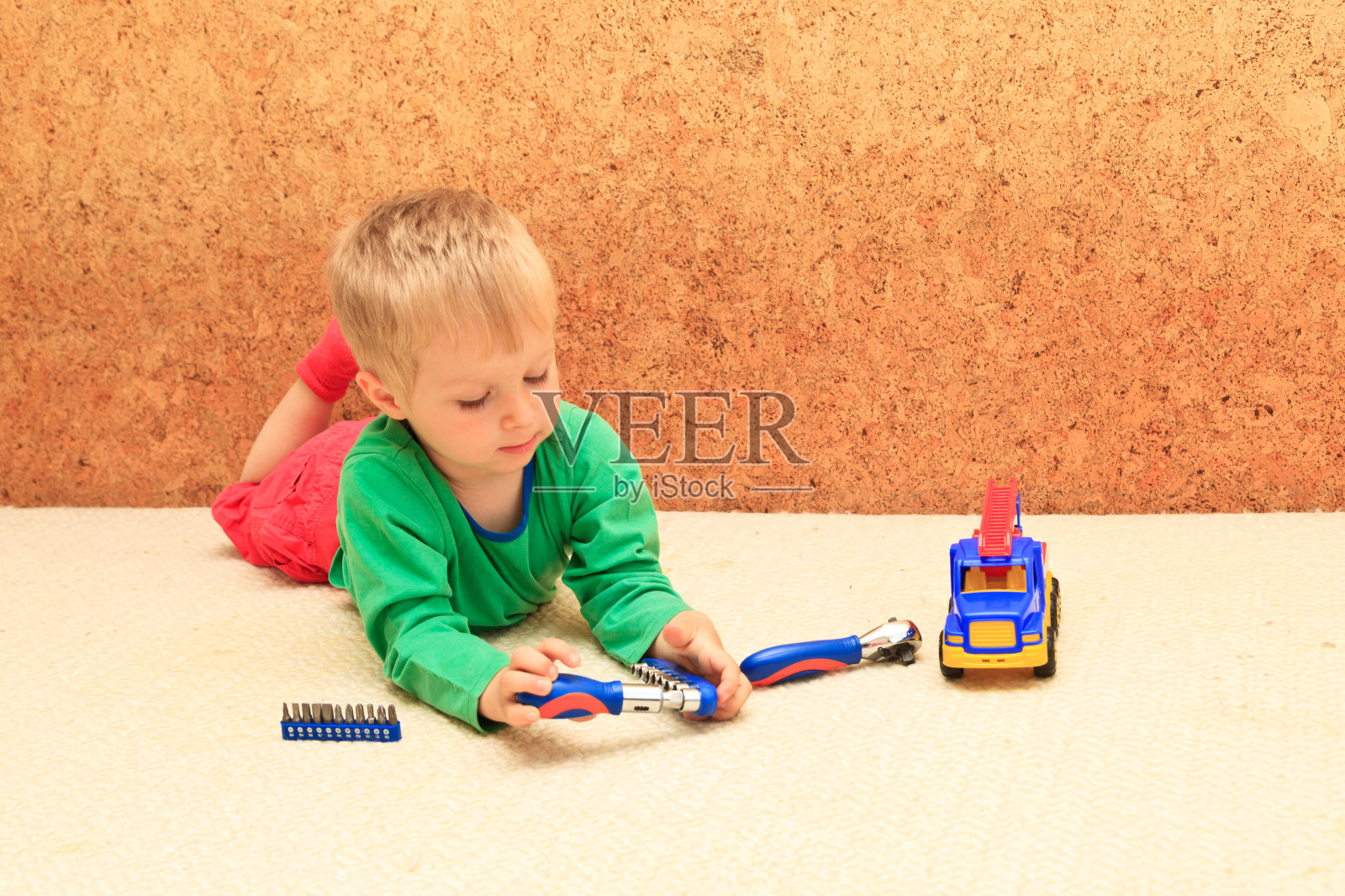 小男孩在修理塑料玩具卡车，早期学习概念照片摄影图片