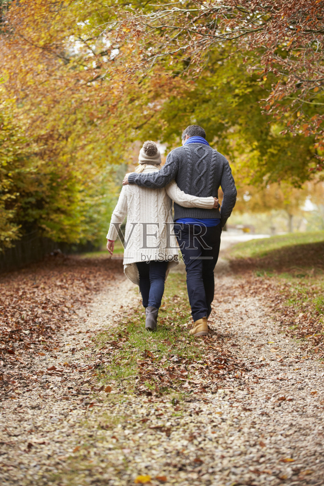 一对夫妇沿着秋日小径散步的后视图照片摄影图片