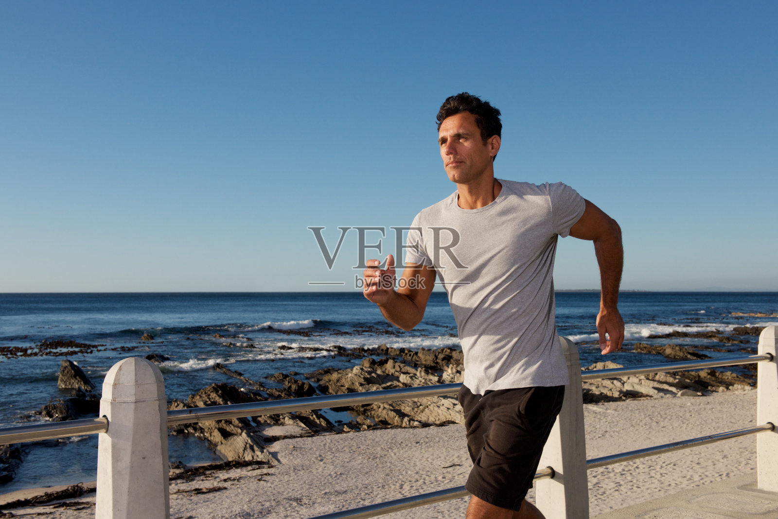 活跃的中年男子在海边慢跑照片摄影图片