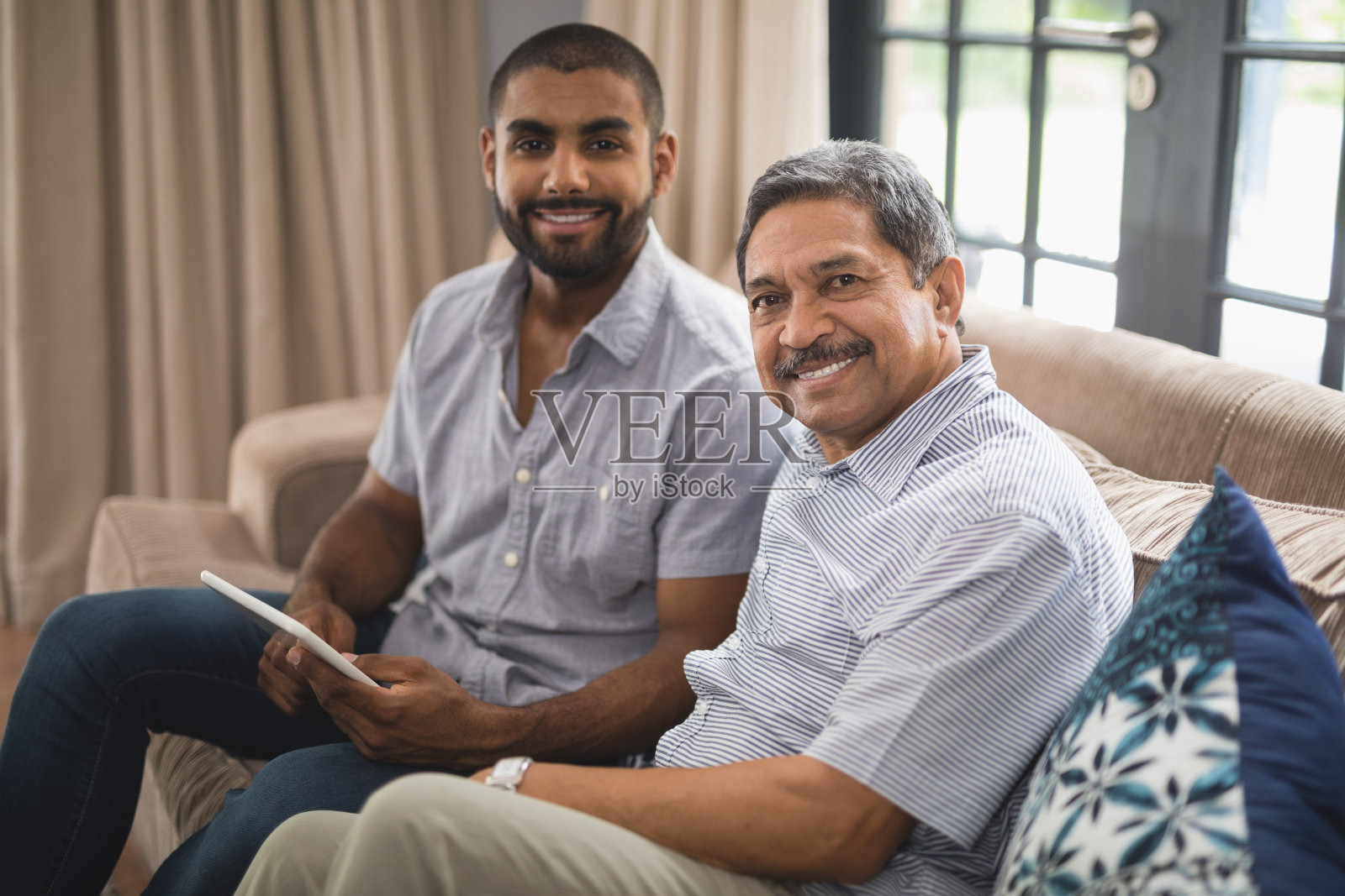 一个男人和他父亲坐在家里沙发上的肖像照片摄影图片