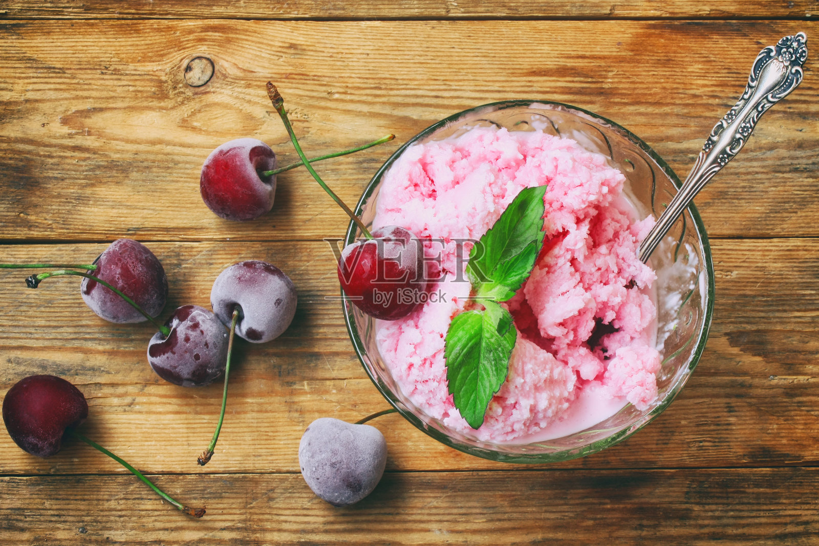 自制酸奶冰淇淋，配樱桃，薄荷叶照片摄影图片