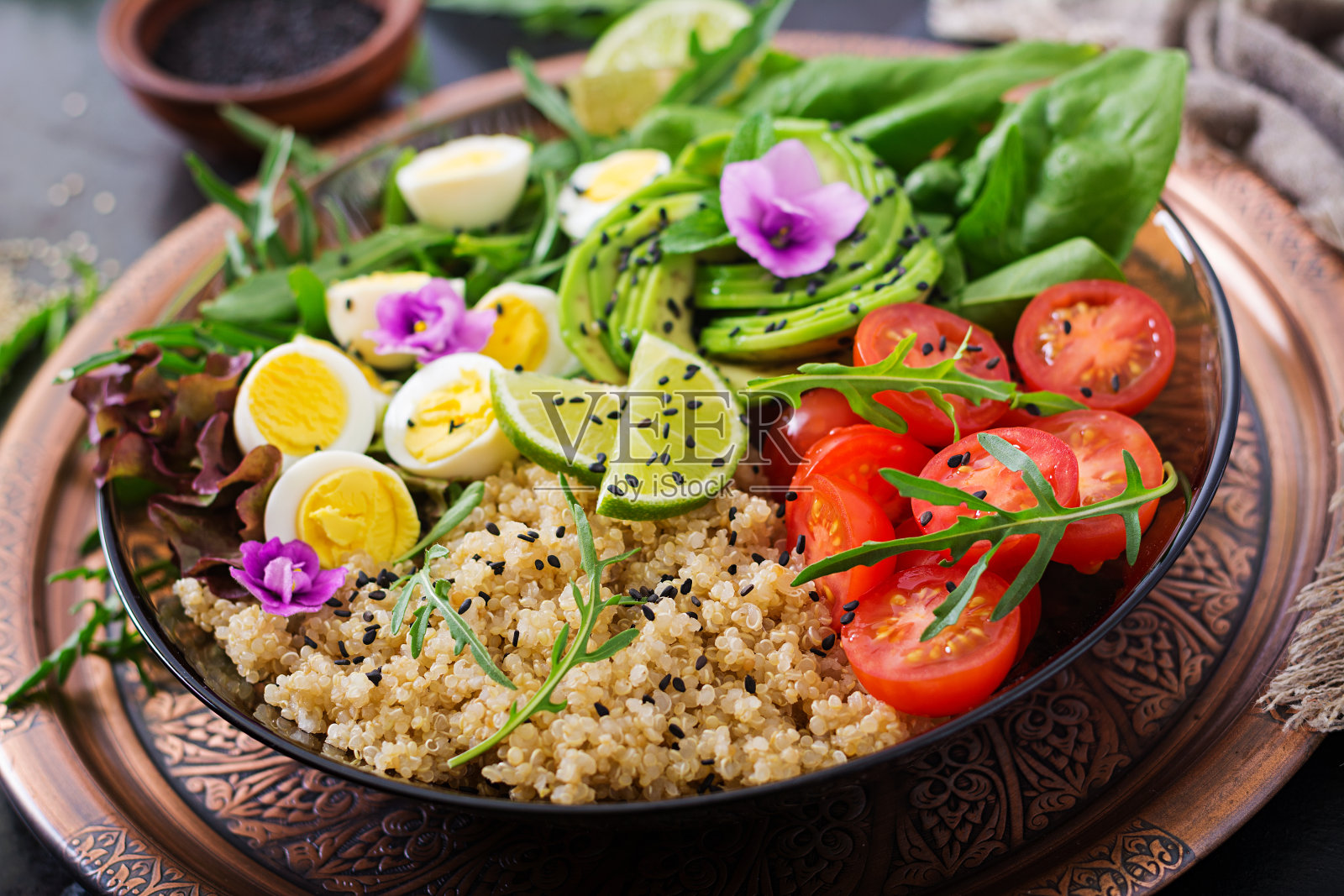 饮食菜单。健康的新鲜蔬菜沙拉-西红柿，鳄梨，芝麻菜，鸡蛋，菠菜和藜麦在碗里照片摄影图片