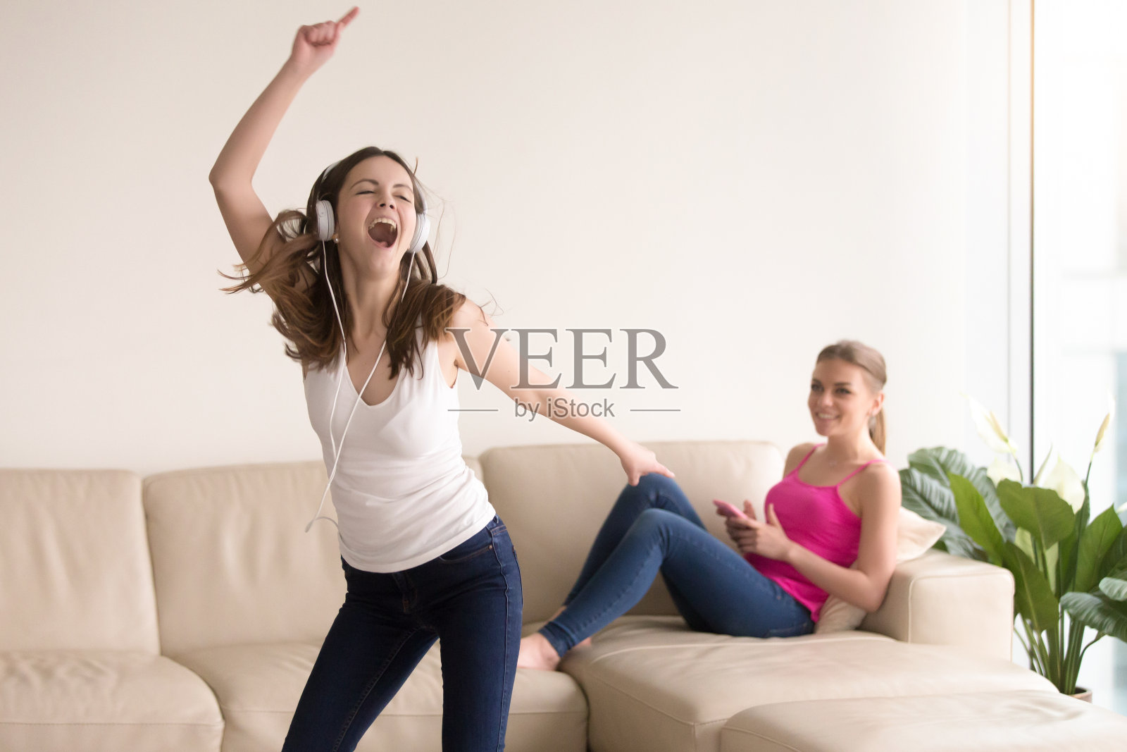 两个快乐的少女在家享受音乐照片摄影图片