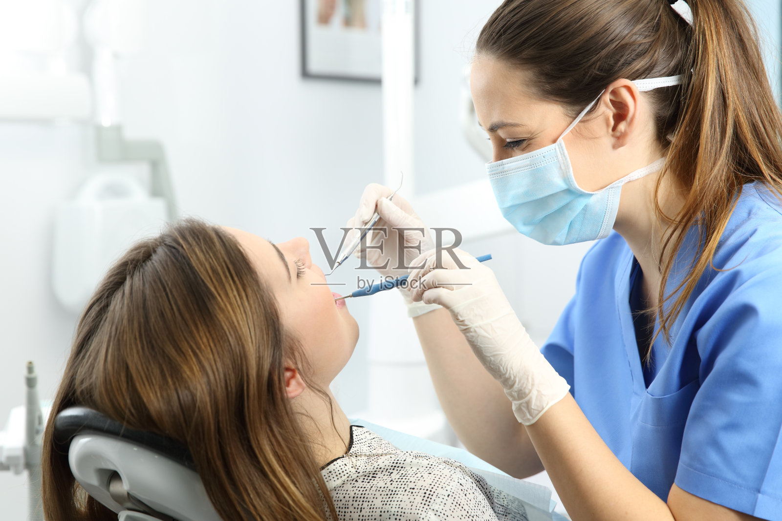 牙科医生在诊所检查病人的牙齿照片摄影图片