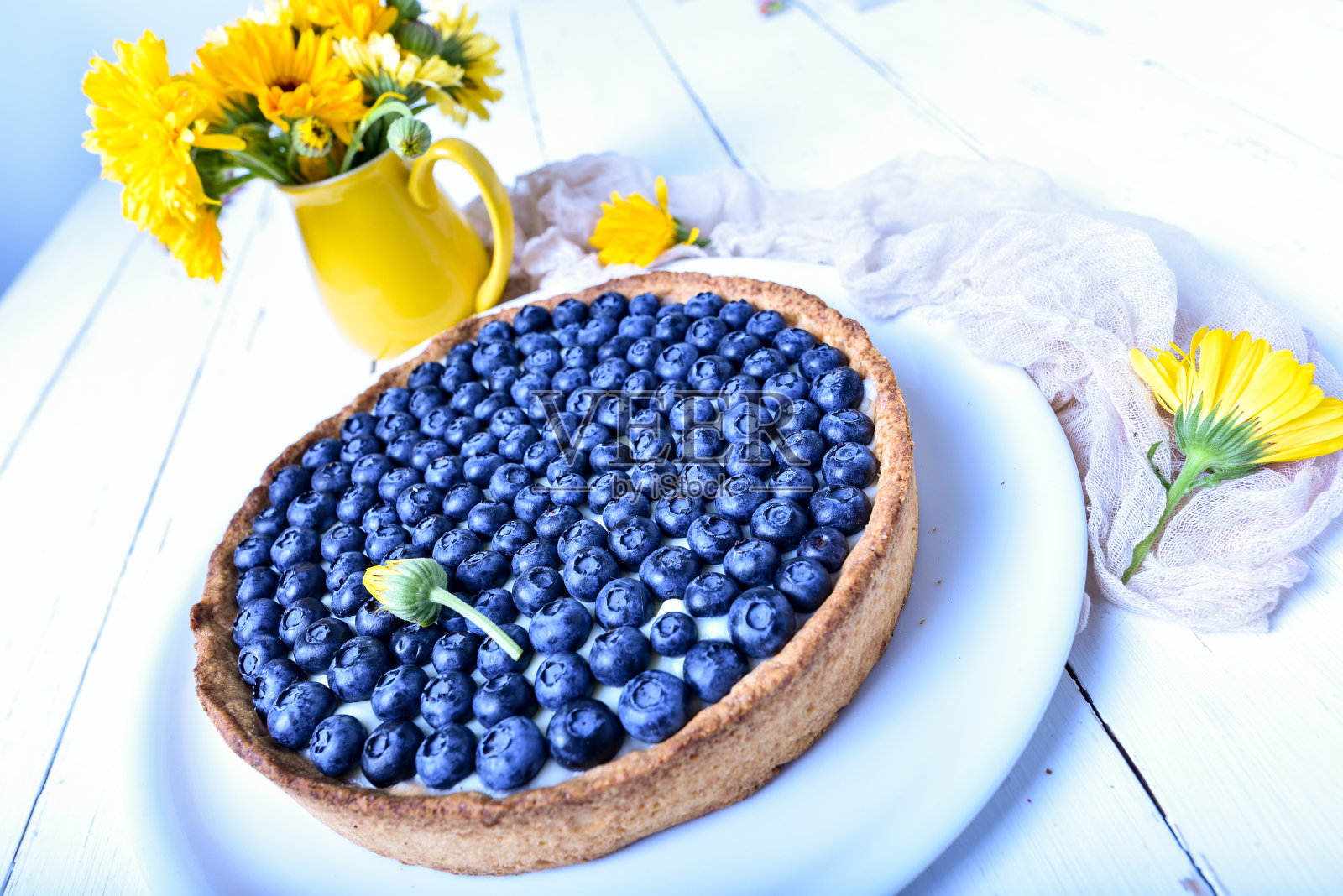 蛋糕和浆果。白色的乡村餐桌上放着夏天盛开的蓝莓派。蓝莓。早餐和早餐概念照片摄影图片