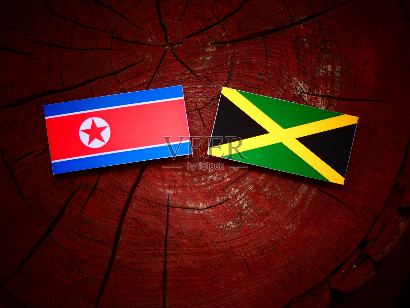 朝鲜国旗和牙买加国旗在一个树桩孤立照片摄影图片