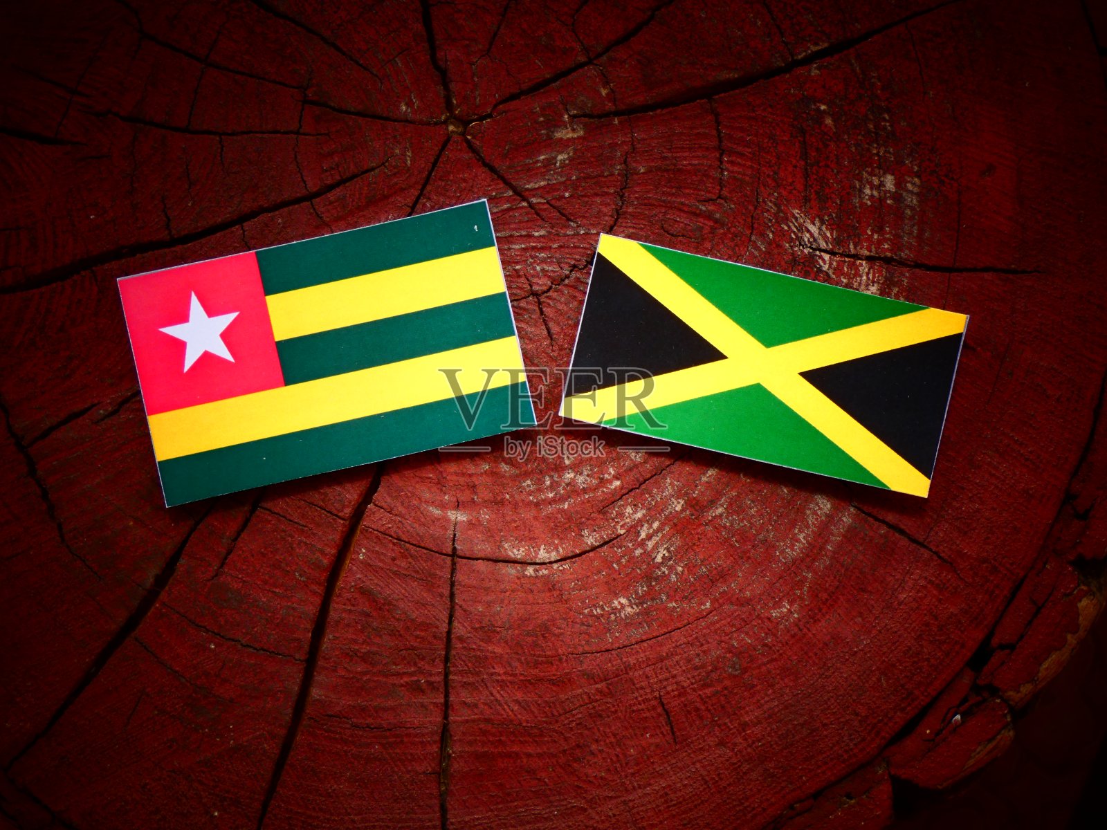 孤立的树桩上挂着多哥国旗和牙买加国旗照片摄影图片