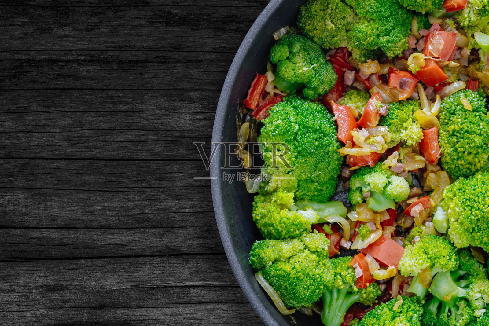 新鲜的夏日沙拉，清炒蔬菜，西兰花和伊比利亚火腿丁放在质朴的木桌上。俯视图照片摄影图片