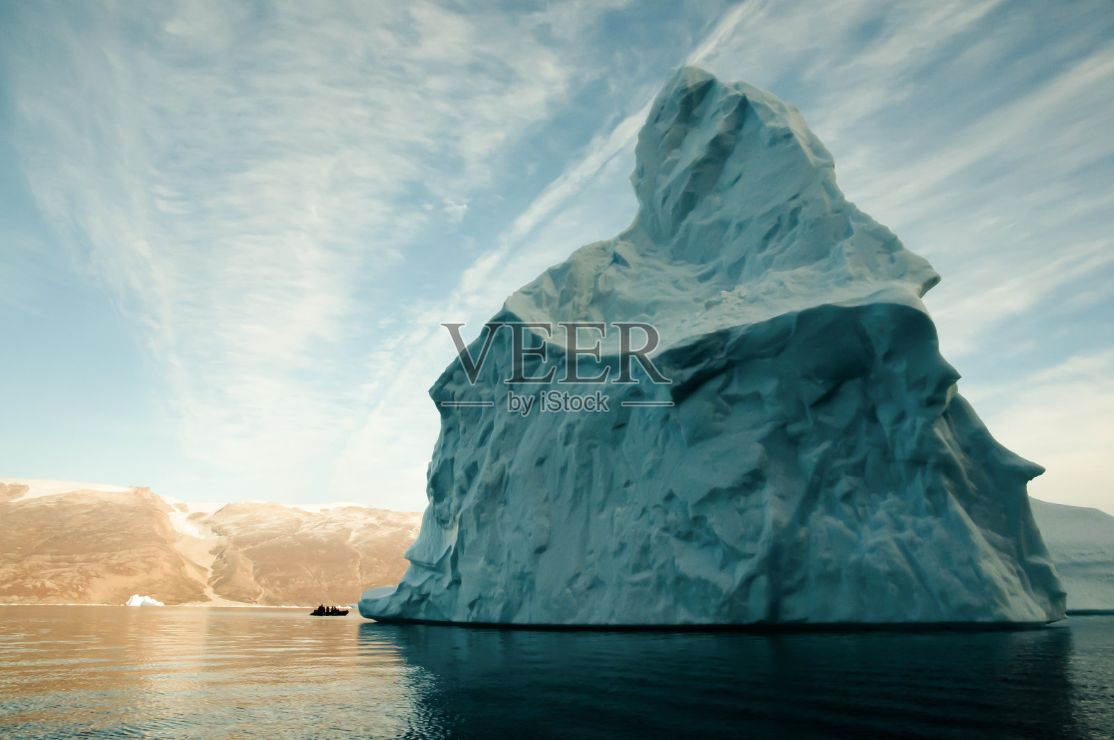 巨大的冰山与充气船规模-格陵兰岛照片摄影图片