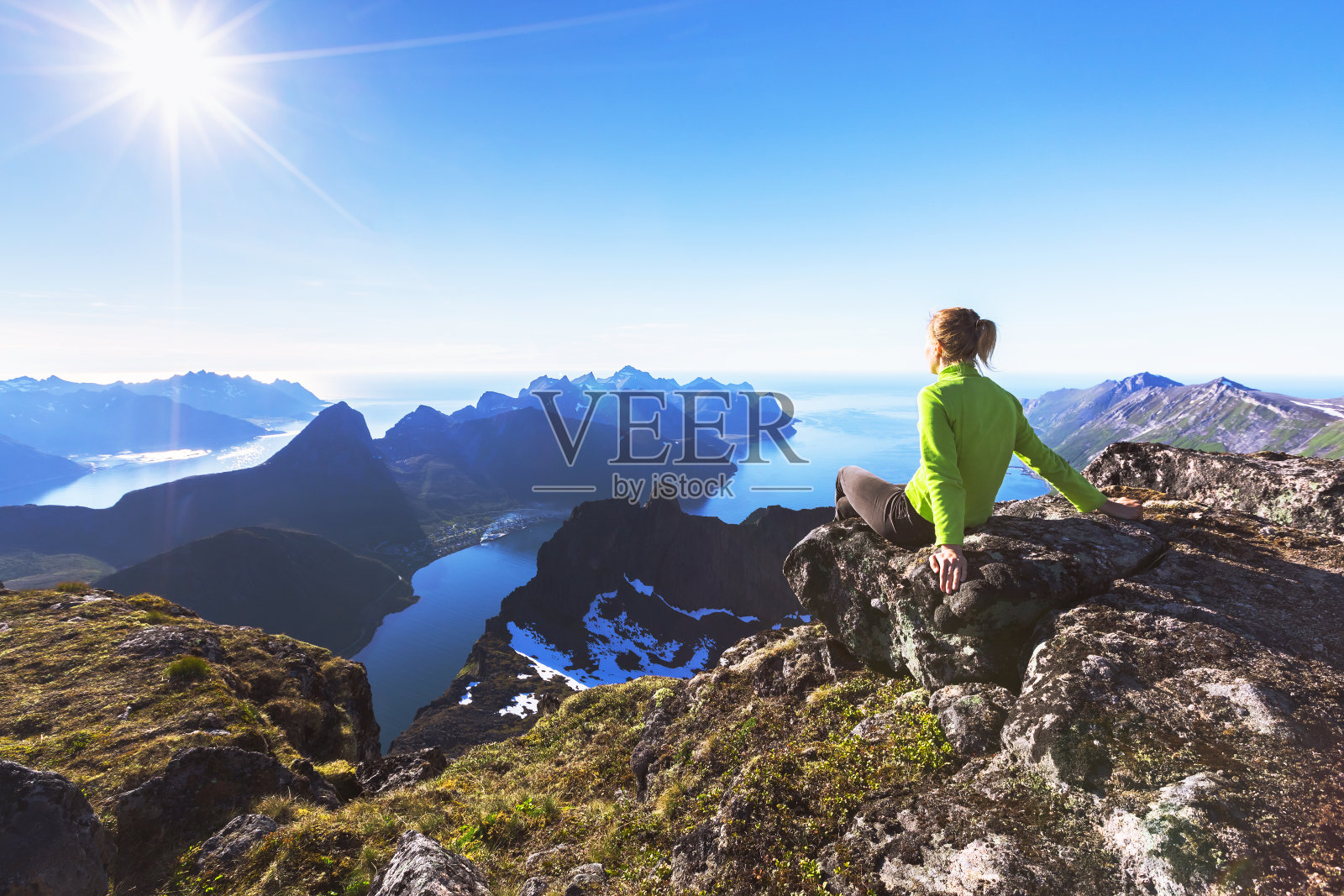 在山顶上的徒步旅行者可以看到挪威峡湾的景色照片摄影图片