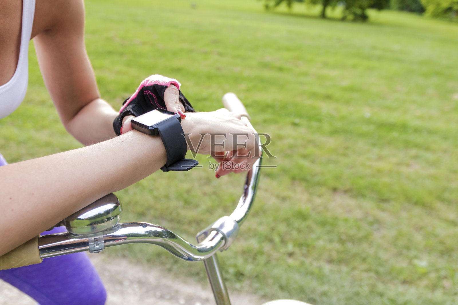 一个骑自行车的女人带着智能手表的心率监测器照片摄影图片