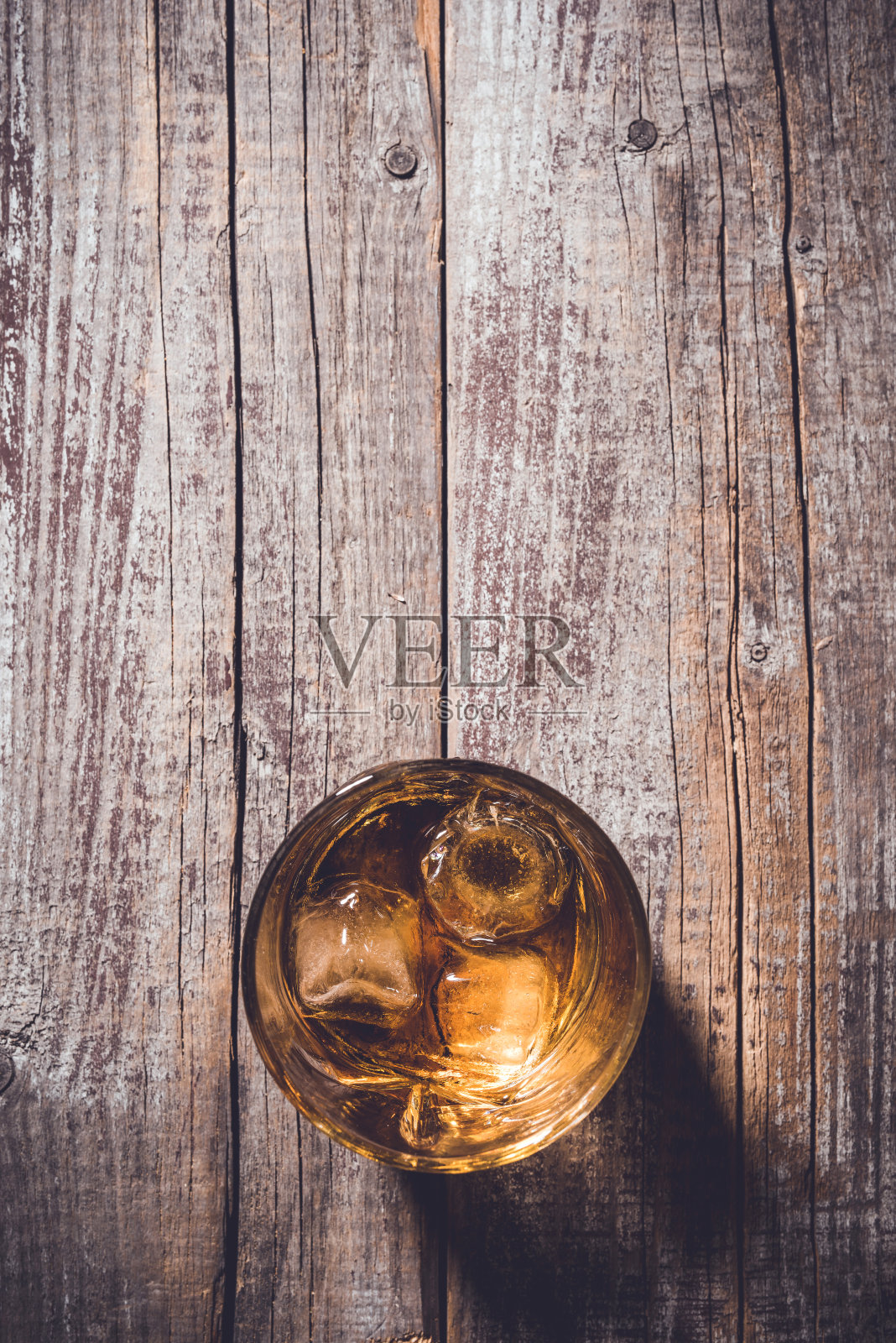 威士忌酒杯放在旧木桌上。照片摄影图片