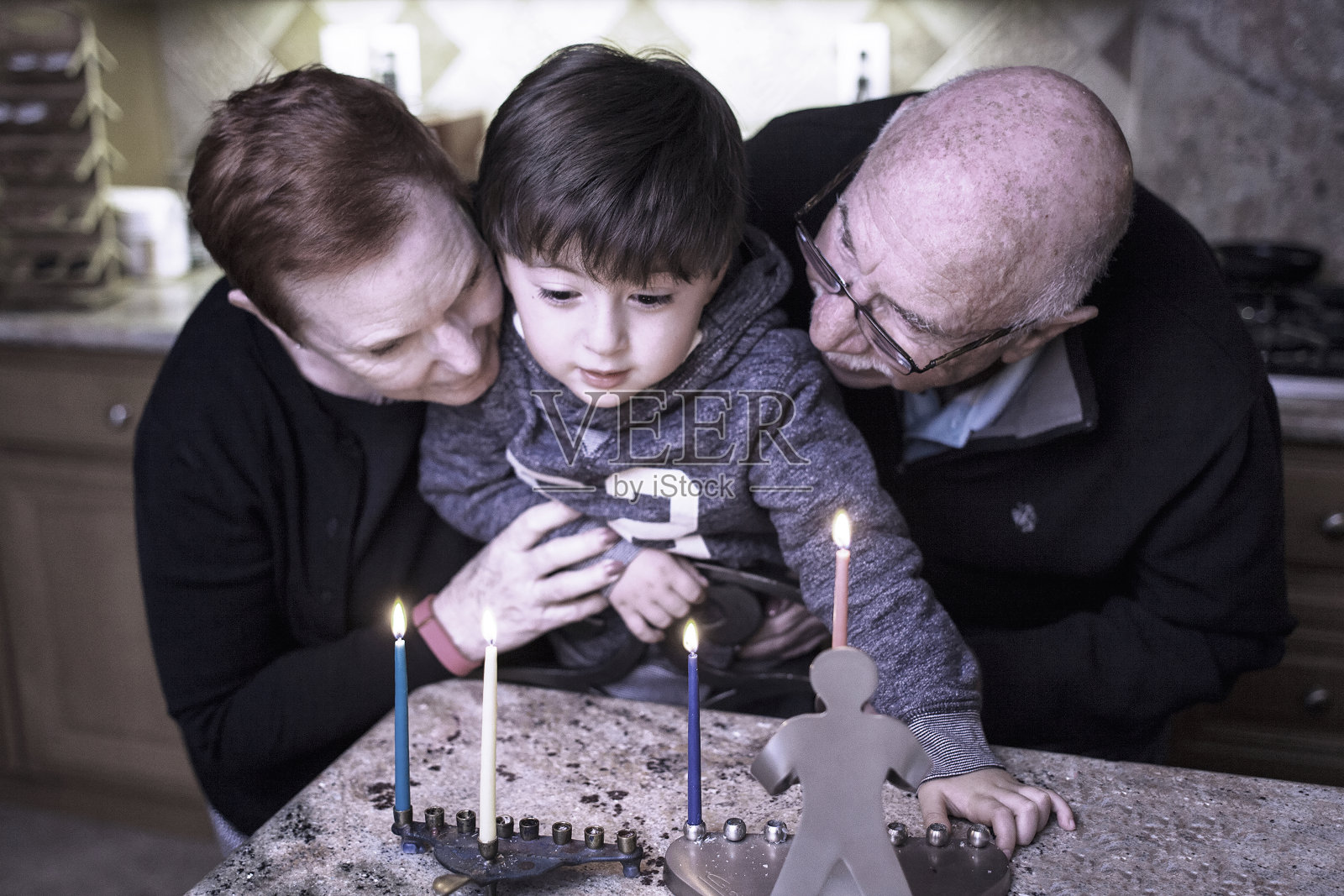 犹太家庭，祖父母和孙子在烛台上点亮光明节蜡烛照片摄影图片
