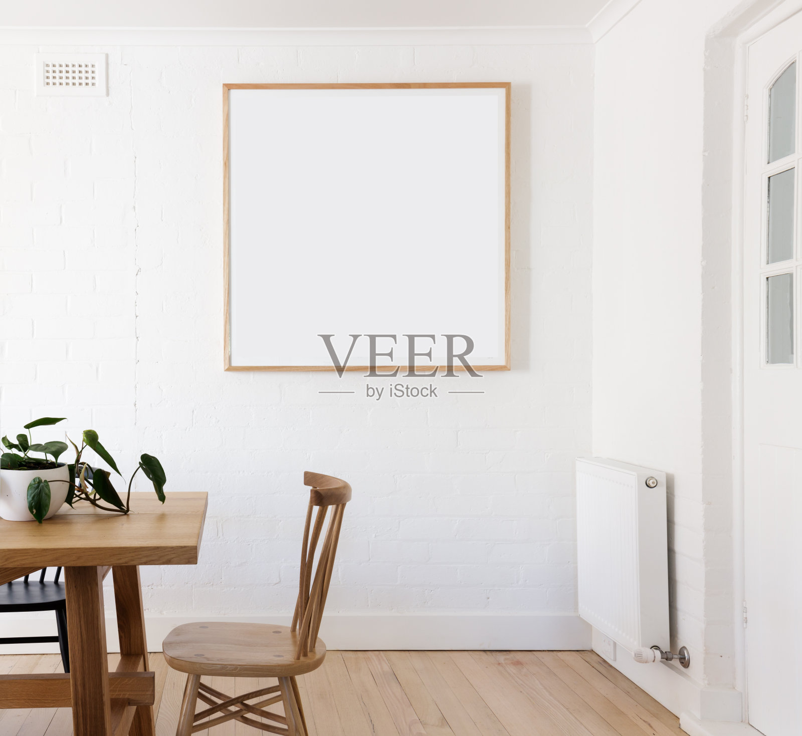 在丹麦风格的室内餐厅的白色墙壁上的空白框打印照片摄影图片