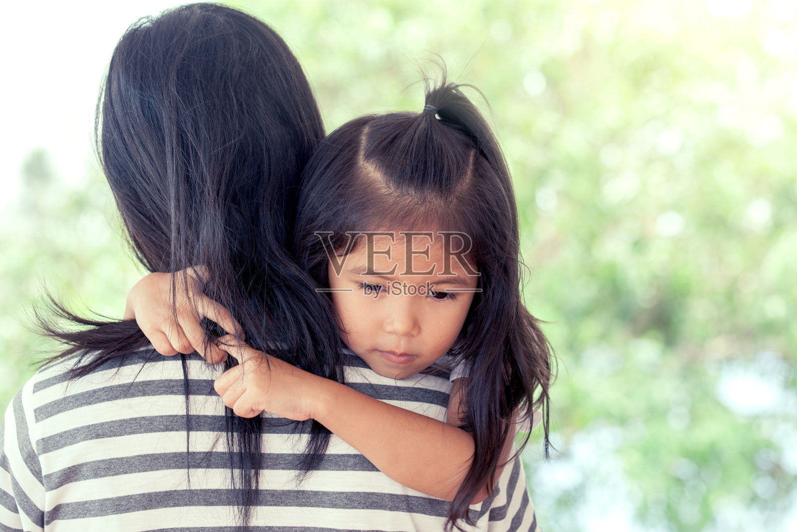 妈妈和孩子可爱的小女孩靠在妈妈的肩膀上照片摄影图片