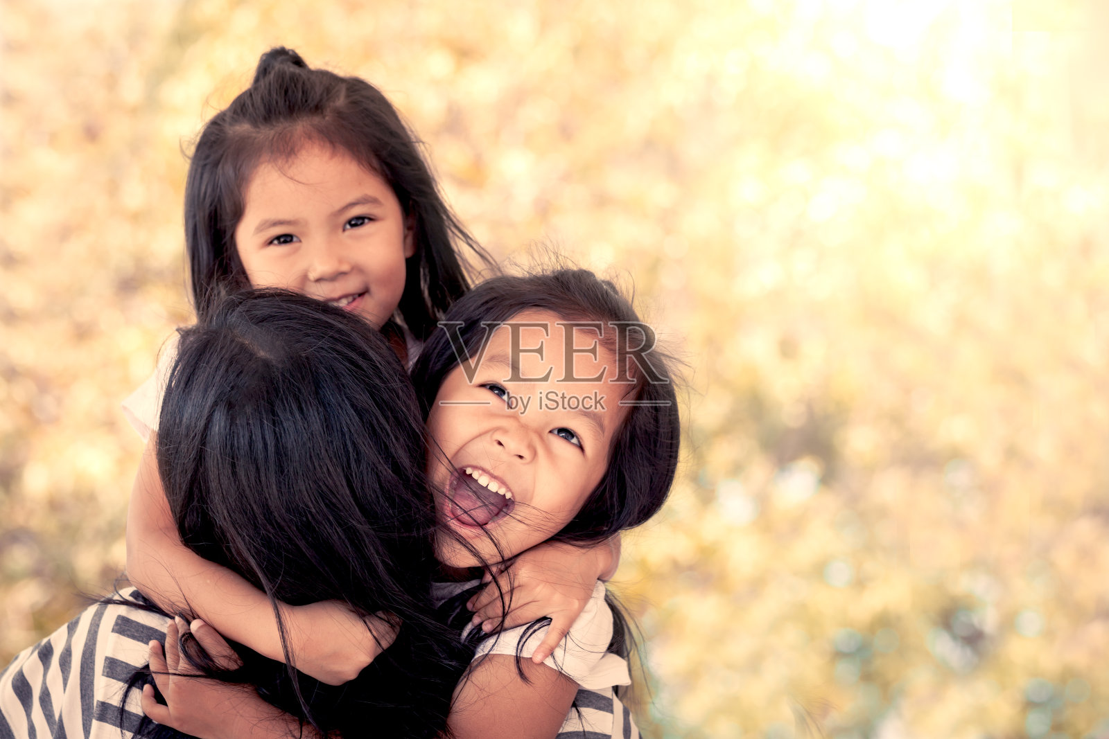 快乐的亚洲小女孩拥抱母亲，并有乐趣与母亲玩照片摄影图片