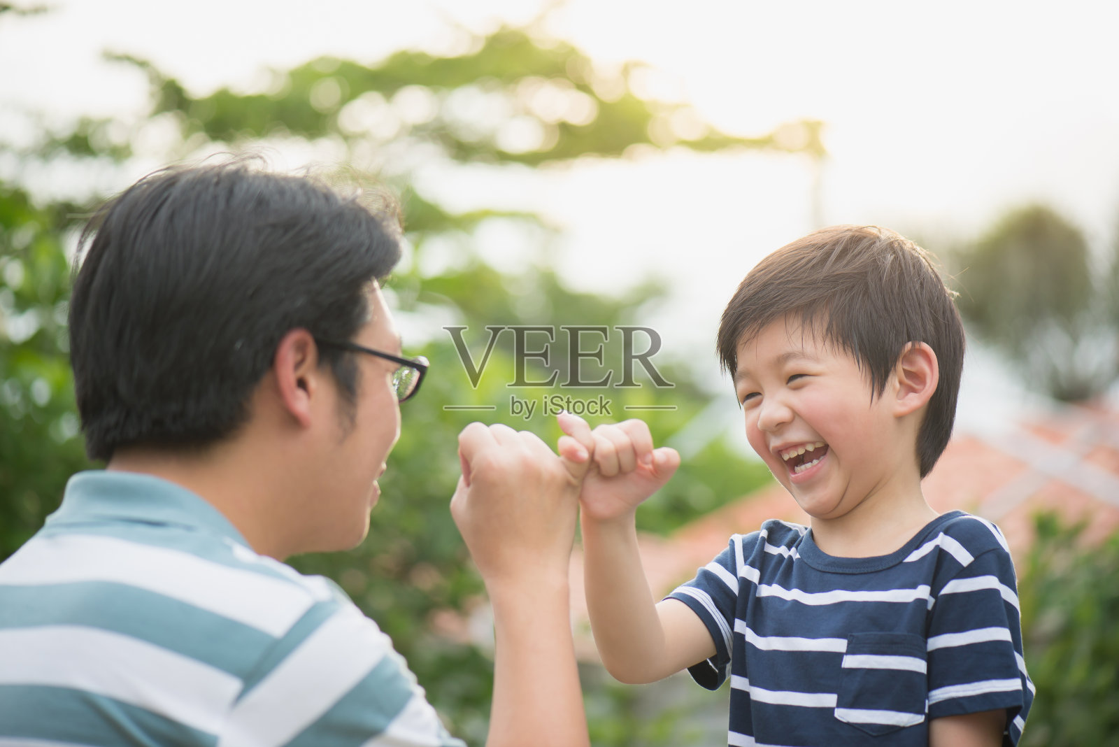 亚裔父亲和他的儿子在做小指承诺照片摄影图片