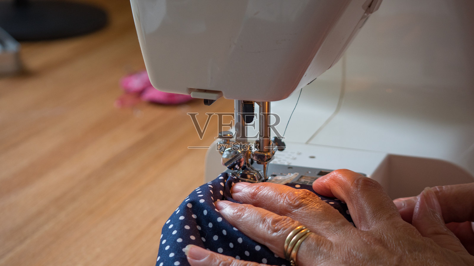 女用手用缝纫机缝制布料照片摄影图片