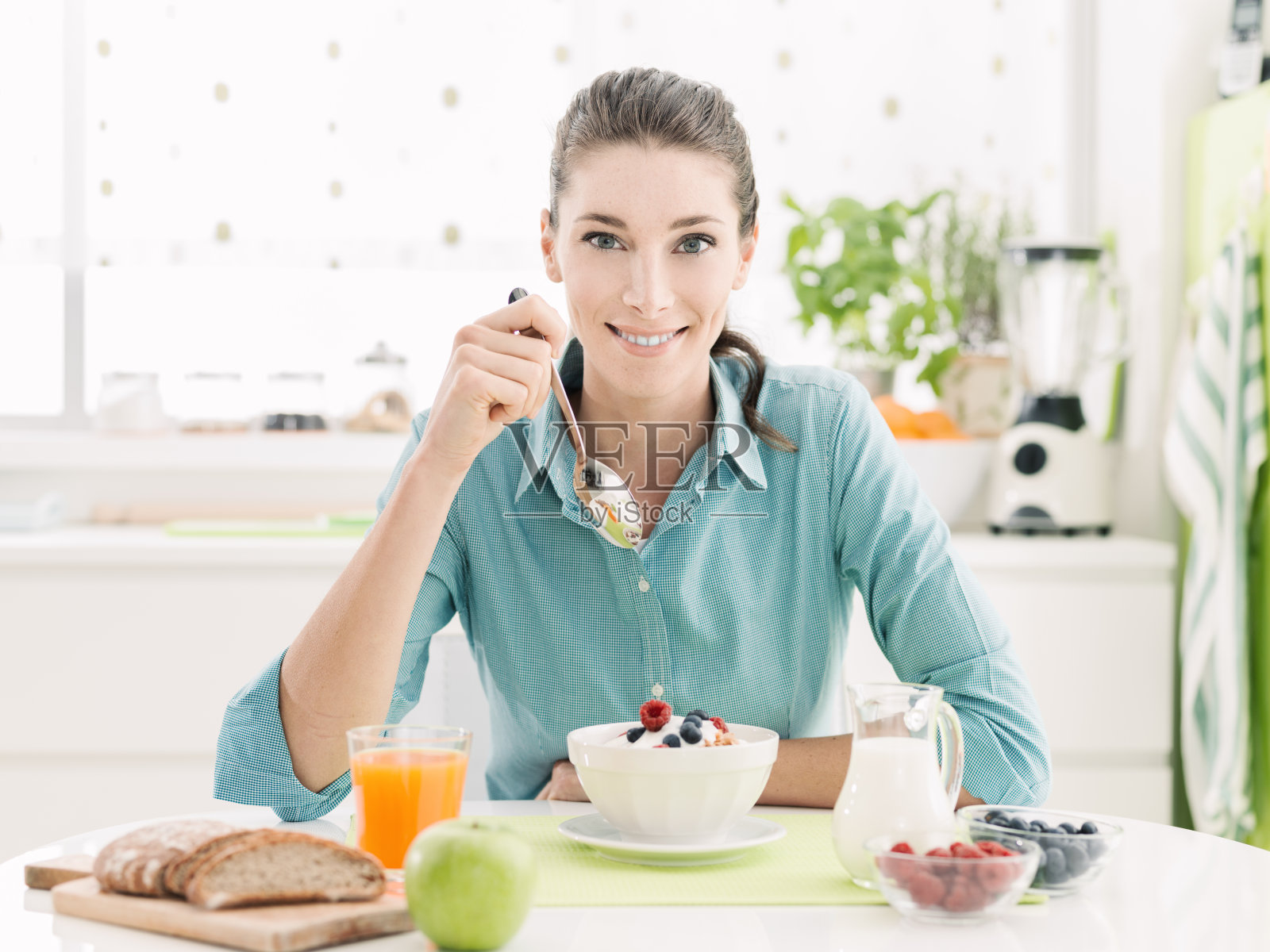 微笑的女人在家里吃早餐照片摄影图片