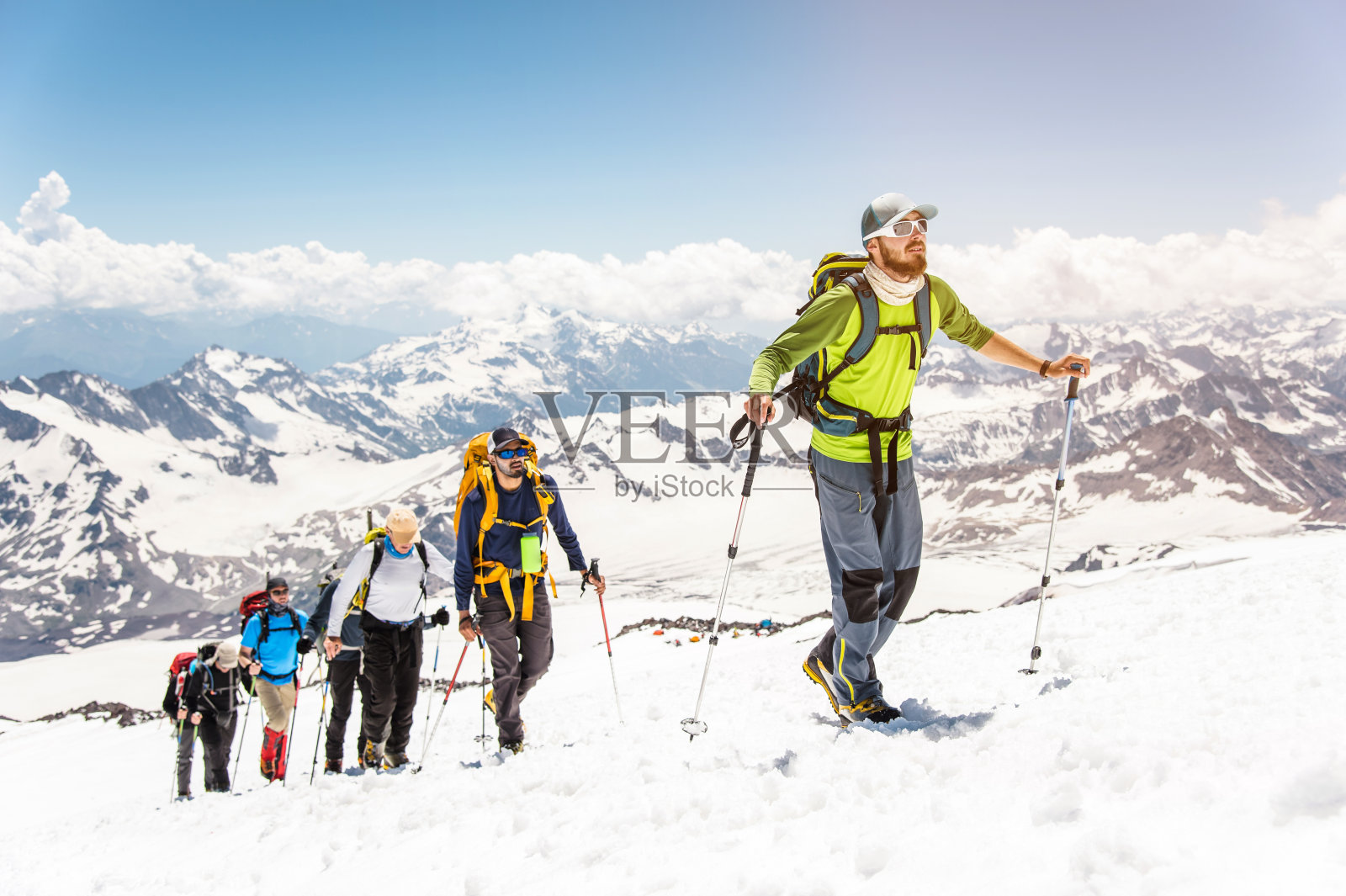 一群登山运动员爬上了一座白雪皑皑的山峰照片摄影图片