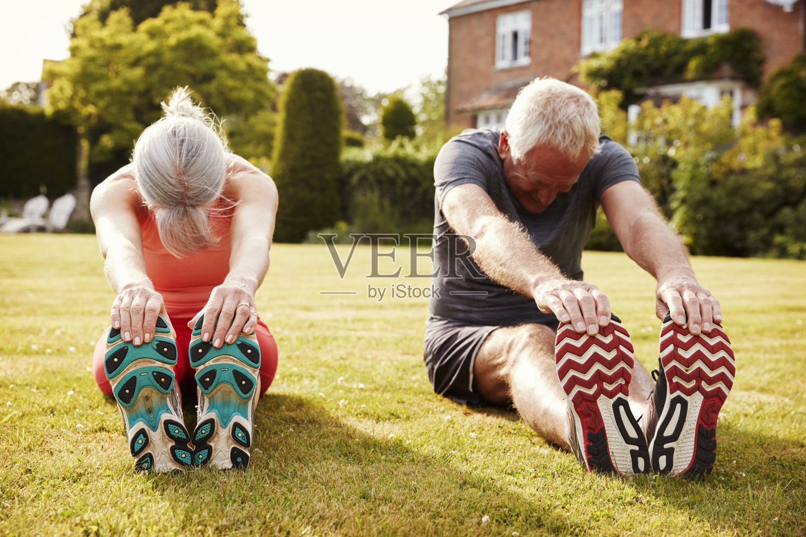 Healthy Senior Couple Exercising In Garden Together照片摄影图片