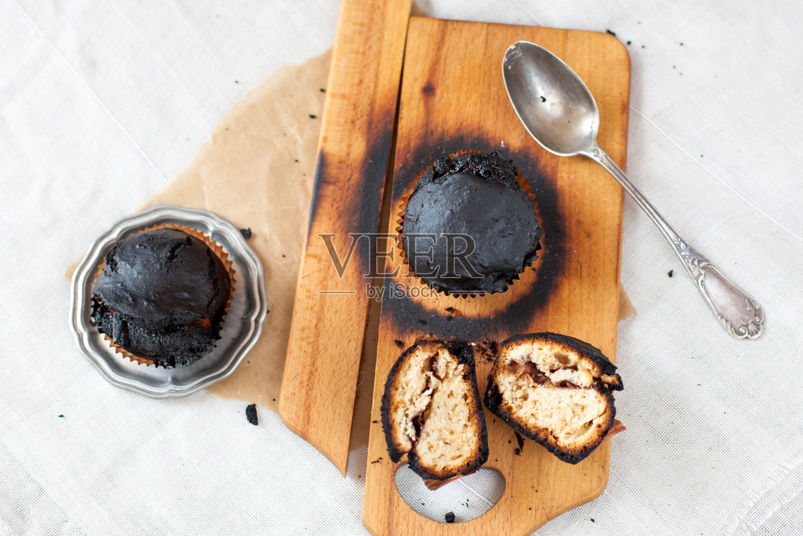 烤焦的松饼——黑色的纸杯蛋糕，烘焙失败，厨房里的灾难，被木炭烧焦照片摄影图片