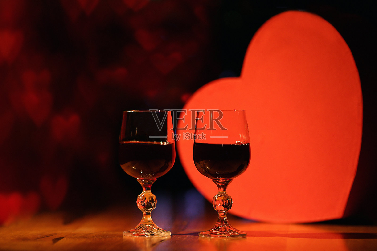 两杯红酒配上美丽的灯光，红心背景照片摄影图片