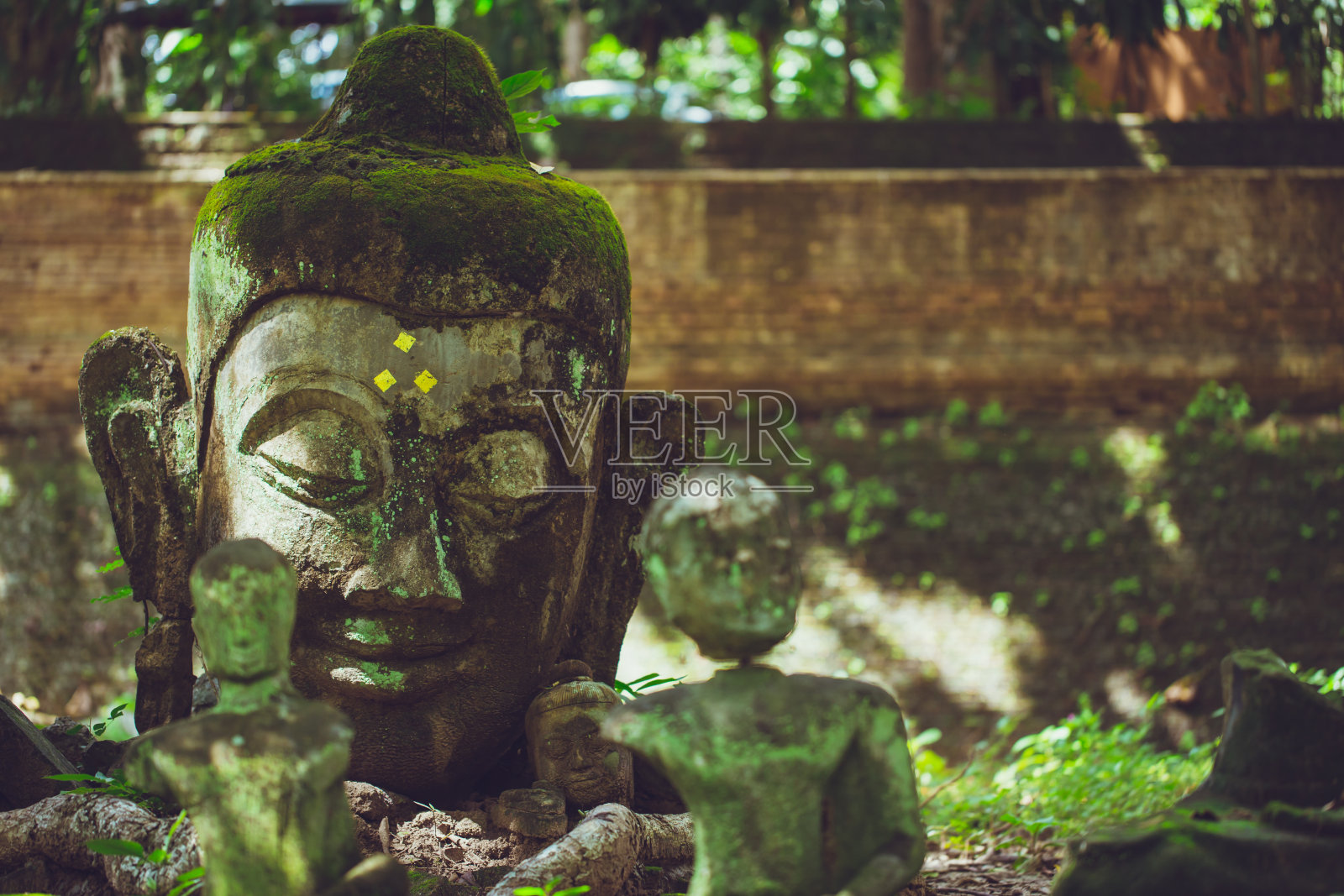 古老的佛像石像，亚洲艺术在泰国清迈吴明寺森林里。照片摄影图片