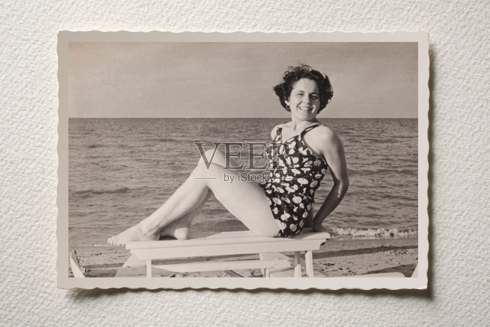 一张老照片，一个微笑的女孩在海上。50年代的照片。照片摄影图片