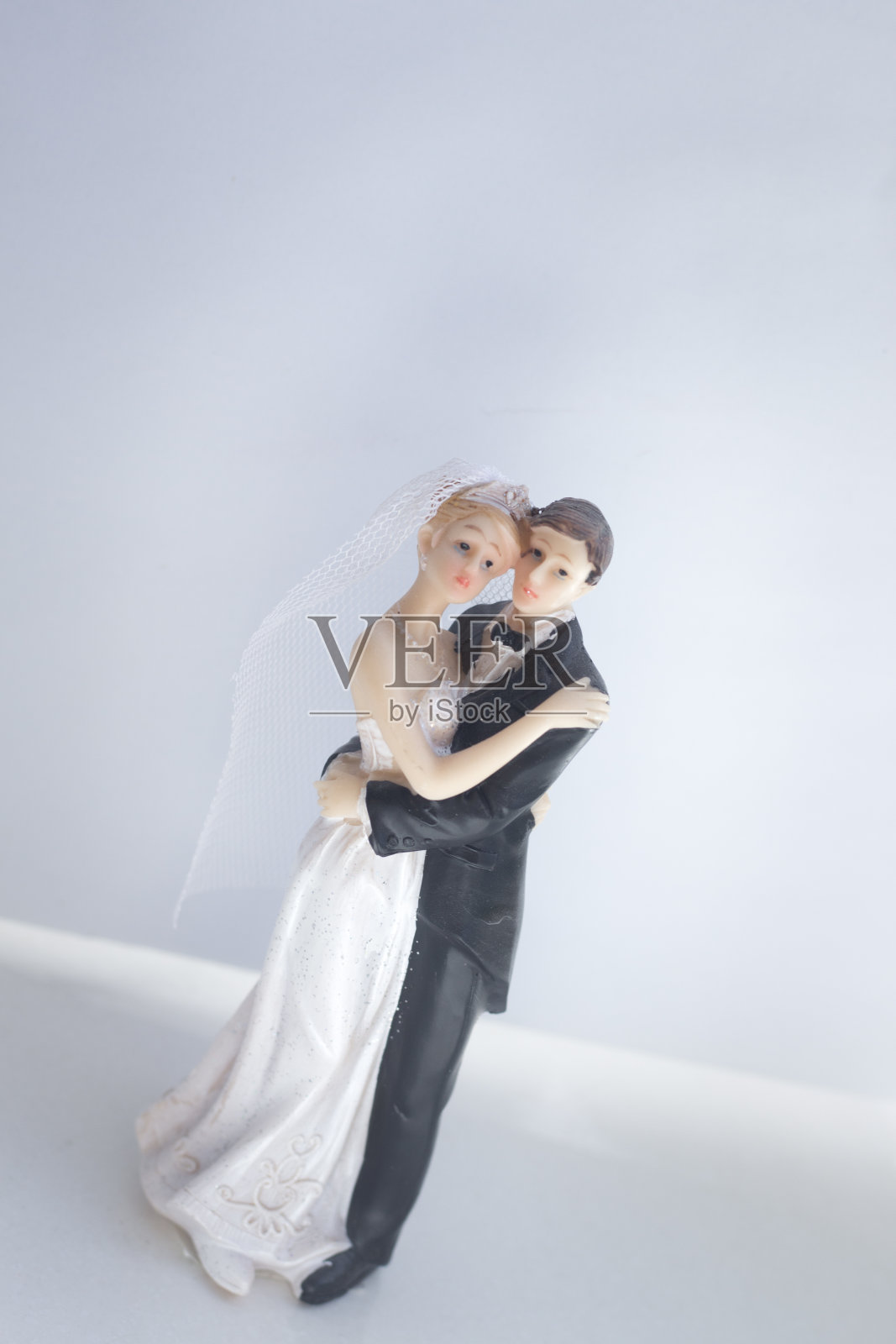新娘和新郎的婚礼蛋糕顶部塑料雕像举行婚礼仪式后。照片摄影图片