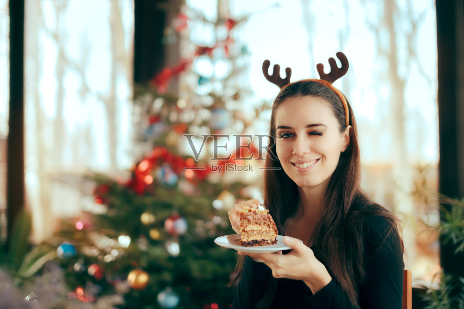 快乐的女人在圣诞晚宴上吃蛋糕照片摄影图片
