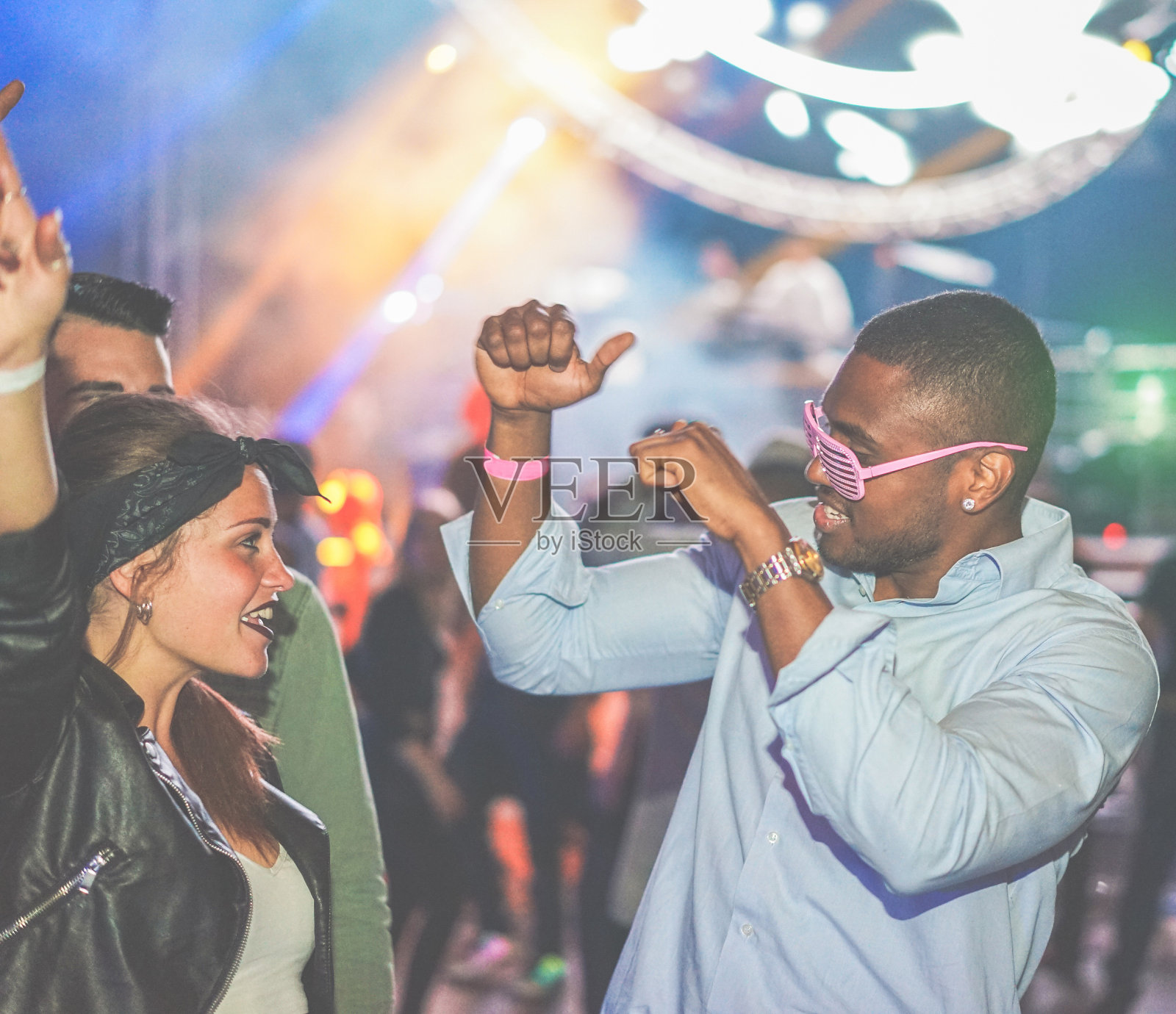 年轻的朋友在夜店跳舞派对-多元文化的人享受周末夜生活与原始激光颜色的背景-青年概念-软焦点黑人-温暖的滤镜照片摄影图片