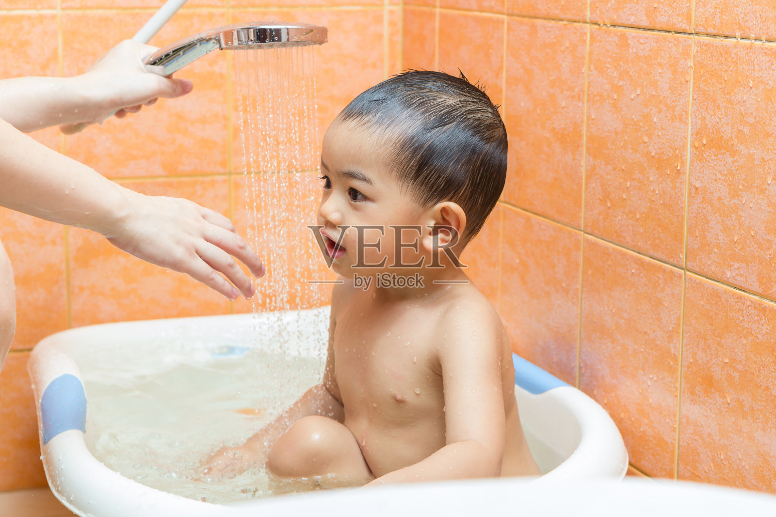 特写2岁的孩子和他的妈妈在浴缸里洗澡照片摄影图片
