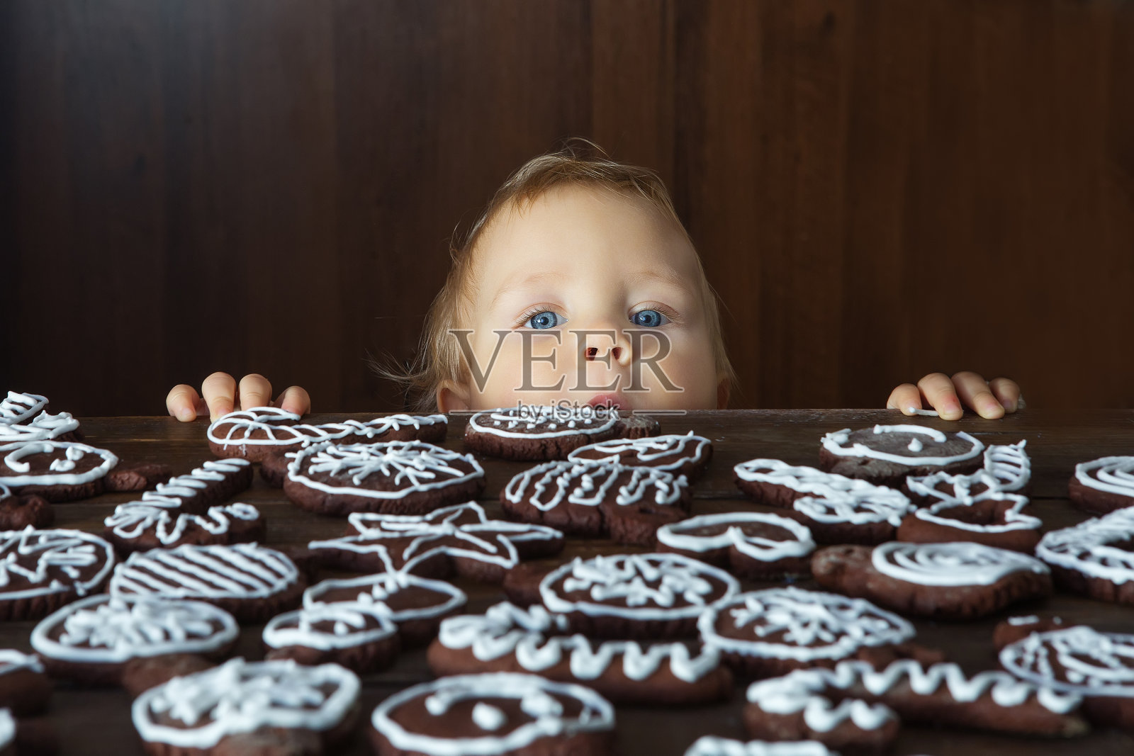小男孩试图抢传统的自制圣诞姜和巧克力饼干装饰白糖画照片摄影图片