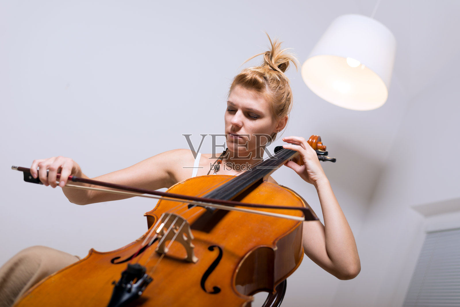 在家拉大提琴的女音乐家照片摄影图片