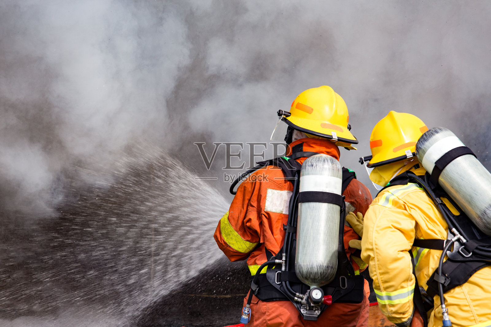 两名消防队员用高压水枪将水喷向火焰周围有烟雾和拷贝空间照片摄影图片