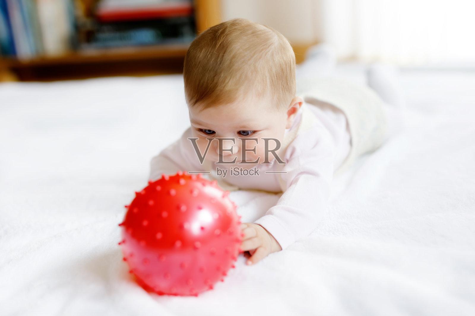 可爱的宝宝玩红色口香糖球，爬，抓照片摄影图片