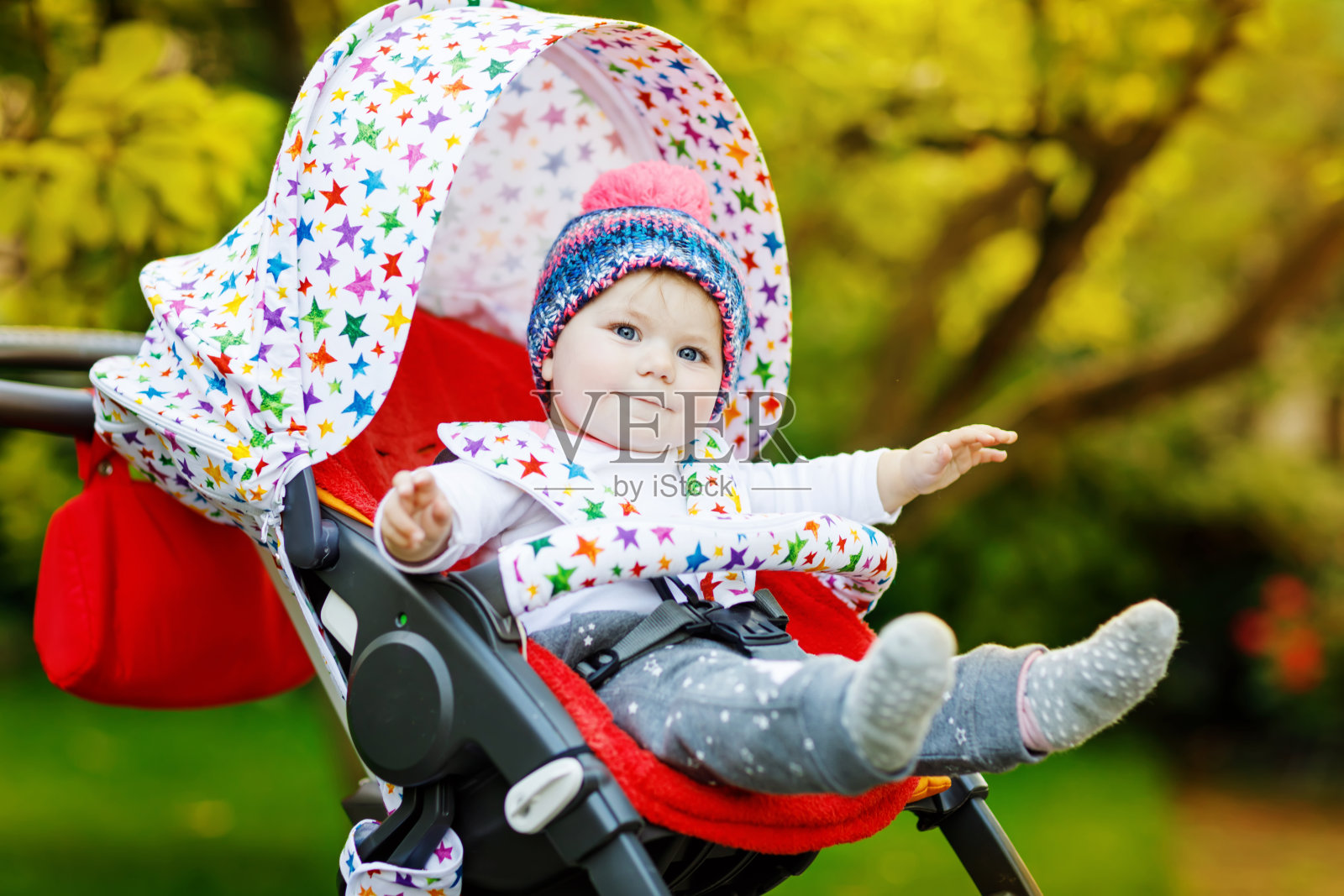 可爱的6个月的小女孩坐在时髦的婴儿车或婴儿车里等待妈妈照片摄影图片