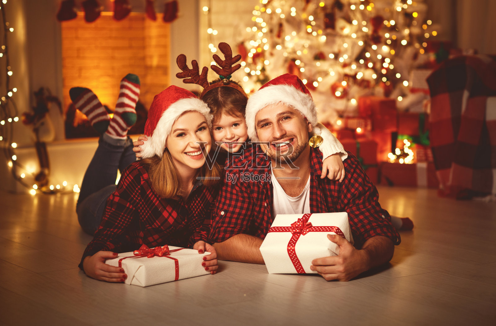 圣诞快乐!幸福的家庭妈妈爸爸和孩子带着神奇的礼物靠近树照片摄影图片
