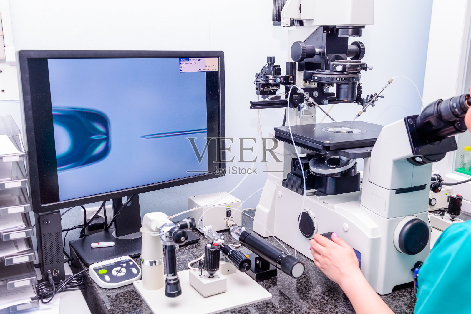 胚胎学家在生殖诊所实验室将精子加入卵子。有选择性的重点照片摄影图片