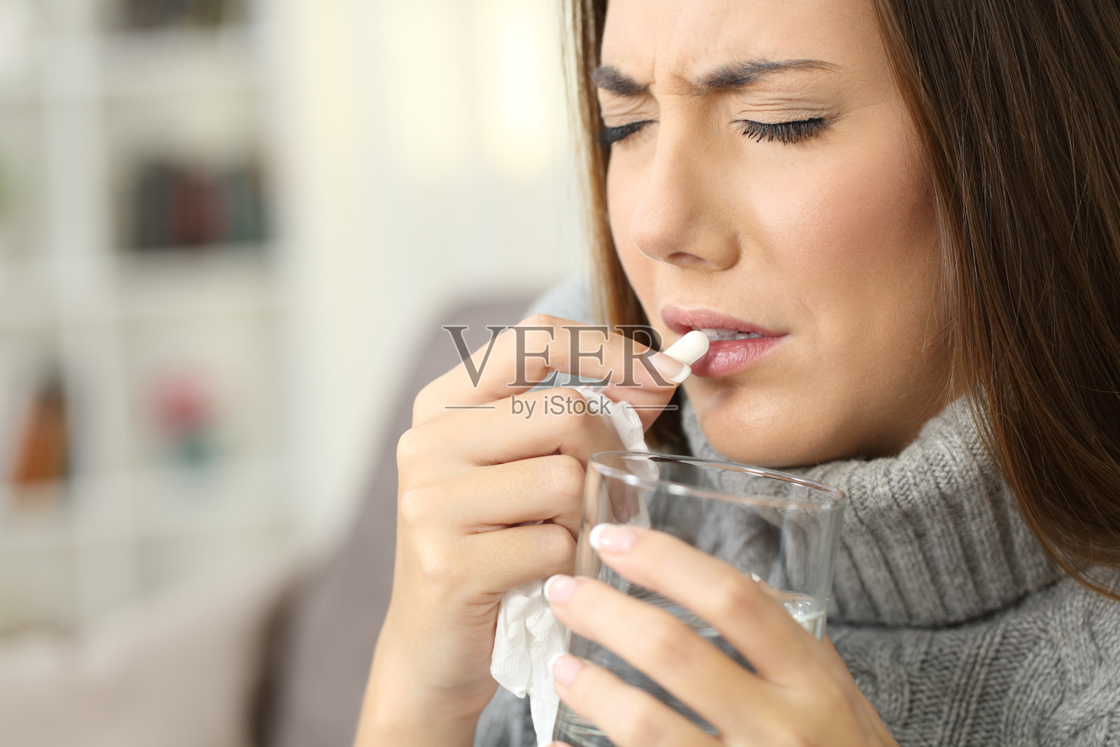 有流感症状的女人正在吃药片照片摄影图片