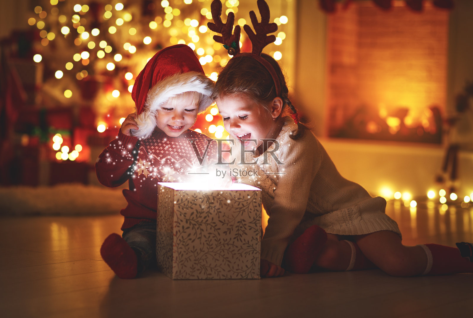 圣诞快乐!快乐的小朋友带着神奇的礼物在家照片摄影图片