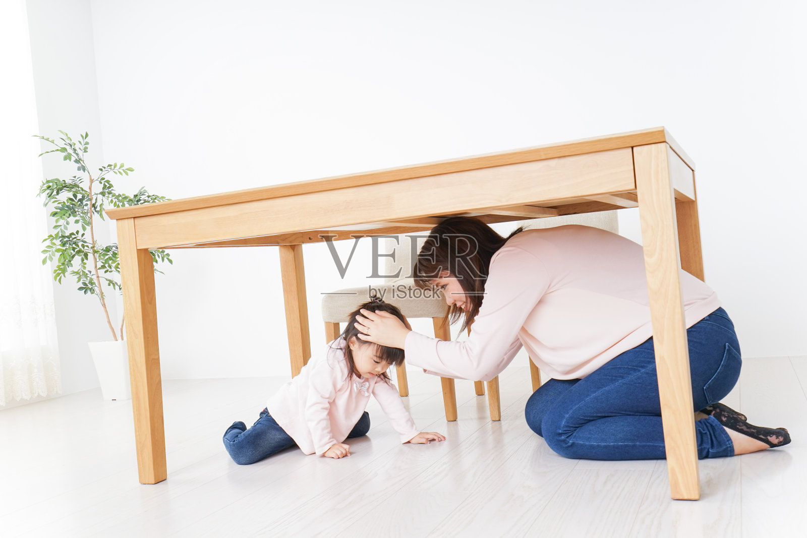 父母和孩子挤在桌子下面照片摄影图片