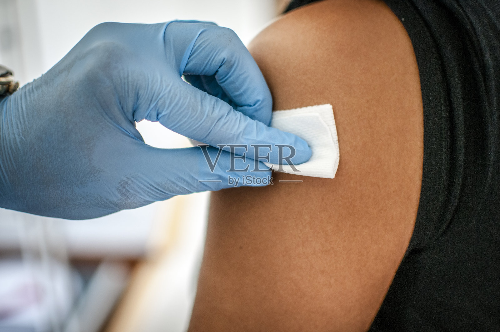 医生在接种疫苗前对病人皮肤进行消毒照片摄影图片